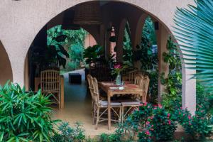 a table and chairs in an arch way with plants at Nomads in Lomé