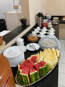 a counter top with a plate of fruit on a table at Hotel e Hostel da Fonte in São Luís