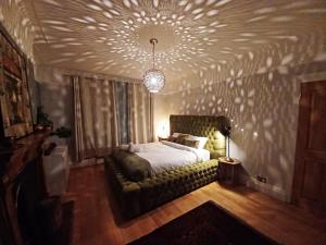 a bedroom with a bed and a couch with a ceiling at The Gemstone Manor in Watford