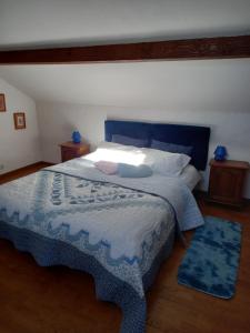 a bedroom with a large bed with a blue headboard at le héron cendré in Lans-en-Vercors