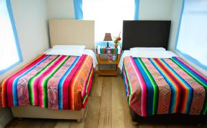 dos camas sentadas una al lado de la otra en una habitación en Quinuawasi House, en Ocosuyo