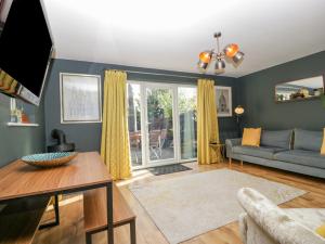 a living room with a couch and a table at 8 Barrington Mews in Ilminster