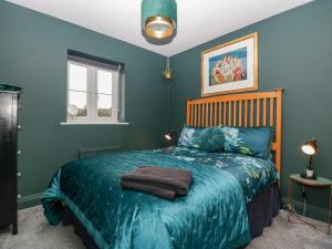 1 dormitorio con 1 cama con paredes azules en 8 Barrington Mews, en Ilminster