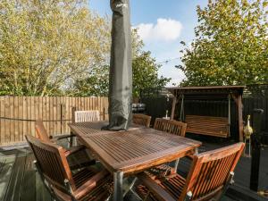 a wooden table and chairs on a patio at 8 Barrington Mews in Ilminster