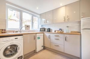 a kitchen with a washing machine and a washer and dryer at Bovey House, single or king beds. Central in Exeter