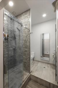 uma casa de banho com uma cabina de duche em vidro e um WC. em FlowSuites Condesa - Adults Only em Cidade do México