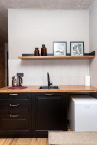 een keuken met zwarte kasten en een spoelbak bij Skio in Goedaoeri +57 foto's