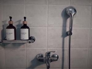 two bottles of soap sitting on a shelf in a shower at Stone House - Bike Friendly Home in Edessa