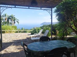 una mesa y sillas en un patio con vistas al océano en Eoliando Case per Vacanze - Lipari, en Lipari