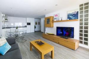 sala de estar con sofá, TV y mesa en NEW CALM Planetcostadorada, en Salou