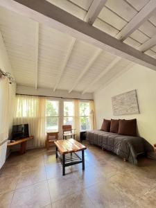 uma sala de estar com uma cama e uma mesa em Portal del Manzano em Villa La Angostura