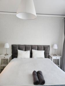 1 cama con 2 toallas y 2 lámparas en Apartament Elite Fundeni sector 2, en Dobroeşti