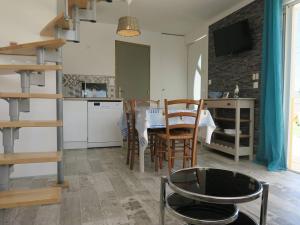 een keuken en eetkamer met een tafel en stoelen bij Maison Perros-Guirec, 3 pièces, 4 personnes - FR-1-368-301 in Perros-Guirec