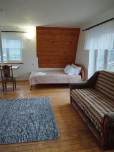 ein Wohnzimmer mit einem Bett und einem Sofa in der Unterkunft Kolo Druziv in Slawske