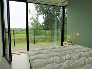 Schlafzimmer mit einem Bett und einem großen Glasfenster in der Unterkunft Maison Pleumeur-Bodou, 4 pièces, 6 personnes - FR-1-368-306 in Pleumeur-Bodou