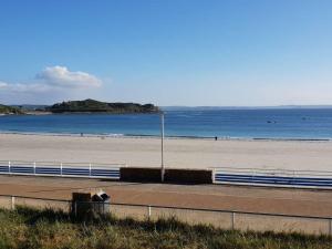 une plage avec une clôture à côté de l'océan dans l'établissement Appartement central à Trébeurden, 500m plage, proche commerces, 2 chambres, 3 salles d'eau - FR-1-368-308, à Trébeurden