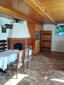 ein Esszimmer mit einem Kamin sowie einem Tisch und Stühlen in der Unterkunft Kolo Druziv in Slawske