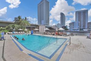 a large swimming pool with people in the water at Awesome Ocean View Modern Condo Pool Shuttle in Hallandale Beach