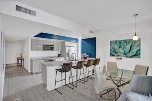 a kitchen and dining room with a glass table and chairs at Awesome Ocean View Modern Condo Pool Shuttle in Hallandale Beach