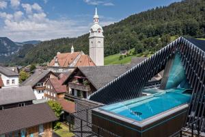 a building with a swimming pool and a clock tower at GAMS zu zweit in Bezau