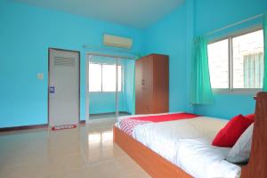 a bedroom with blue walls and a bed at OYO 496 Chok Phikul Thong Resort in Nakhon Pathom