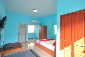 a bedroom with blue walls and a bed and a door at OYO 496 Chok Phikul Thong Resort in Nakhon Pathom