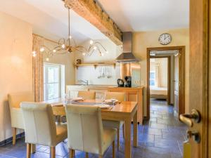 eine Küche und ein Esszimmer mit einem Holztisch und Stühlen in der Unterkunft Chateau Mon Dieu in Aywaille
