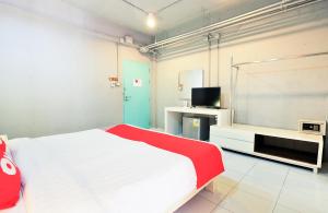 a bedroom with a bed and a tv in it at OYO 292 The Oddy Hip Hotel in Patong Beach