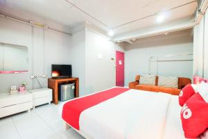 a bedroom with a large bed and a television at OYO 292 The Oddy Hip Hotel in Patong Beach