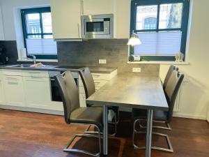a kitchen with a table and chairs and a microwave at "Windrose" in der Villa am Marienhof in Borkum