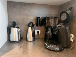 eine Küchentheke mit zwei Kaffeetöpfen und einer Uhr in der Unterkunft "Windrose" in der Villa am Marienhof in Borkum