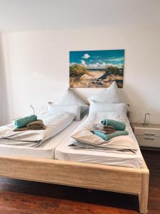 2 Betten in einem Zimmer mit Wandgemälde in der Unterkunft "Windrose" in der Villa am Marienhof in Borkum