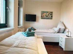 ボルクムにある"Windrose" in der Villa am Marienhofのベッド1台とテレビが備わる小さな客室です。