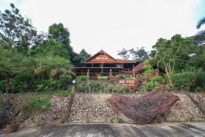 a house in the middle of a garden at OYO 75353 Loy Chalet Resort in Lan Saka