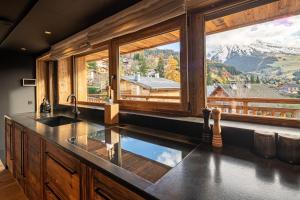 a kitchen with a large window with a mountain view at Chalet Enigma in La Clusaz