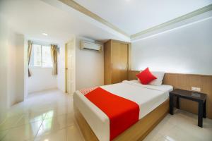 A bed or beds in a room at OYO 232 Patong City Hometel