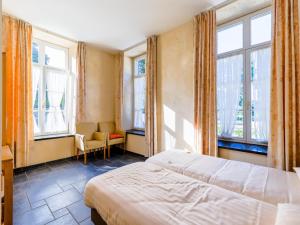 ein Schlafzimmer mit einem Bett und einigen Fenstern in der Unterkunft Chateau Mon Dieu in Aywaille