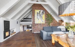 un soggiorno con un divano e un muro di mattoni di Four-Bedroom Holiday Home With A Fireplace In Rømø a Toftum