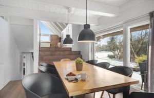 una sala da pranzo con tavolo in legno e sedie nere di Four-Bedroom Holiday Home With A Fireplace In Rømø a Toftum
