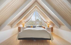 un letto in una camera con una grande finestra di Four-Bedroom Holiday Home With A Fireplace In Rømø a Toftum