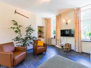 ein Wohnzimmer mit 2 Stühlen und einem TV in der Unterkunft Chateau Mon Dieu in Aywaille