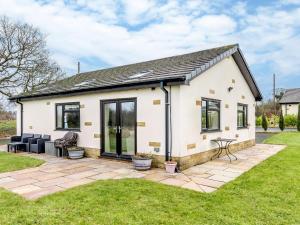 een vrijstaand huisje met een patio in een tuin bij Sunnyside Shreyas in Wilpshire