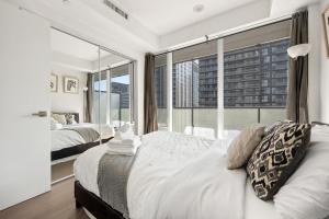 a bedroom with a bed and a large window at Trendy 1bedroom Downtown Toronto Condo in Toronto
