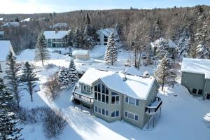 eine Luftansicht eines Hauses im Schnee in der Unterkunft RE90 Rare riverfront family retreat - private slopeside home with AC, fast WiFi, and views in Bretton Woods