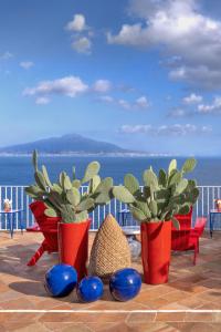 three red vases with plants in them on a balcony at Maison La Minervetta in Sorrento +32 photos