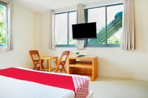 1 dormitorio con 1 cama, TV y mesa en OYO 674 Greenery Home, en Ban Nam Sai