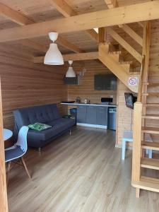 een woonkamer met een blauwe bank en een keuken bij Sarbinowo SOMMER in Sarbinowo