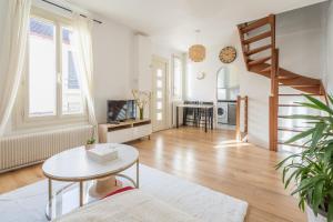 uma sala de estar com uma escada e uma mesa em Paris JO 2024 L élégante em Soisy-sous-Montmorency
