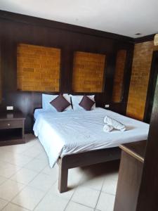 a bedroom with a large bed with white sheets and pillows at Wilai Villa Lamai in Lamai