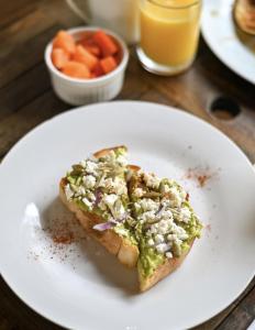 a white plate with a piece of bread with a green dip at Cacao Boutique Hotel in Antigua Guatemala +72 photos